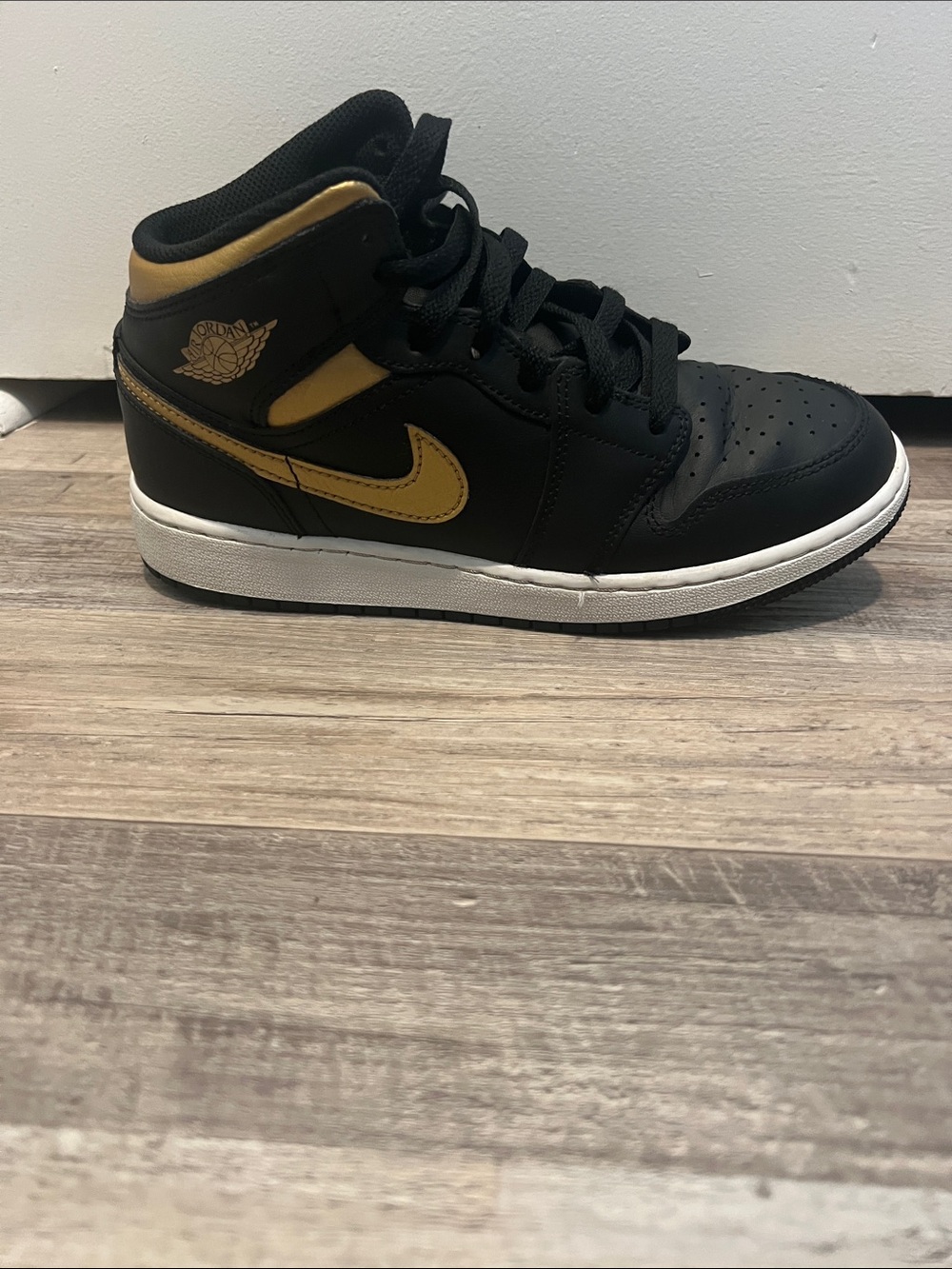 Nike Air Jordan 1 Metallic Black and Gold Mid-Top Sneakers